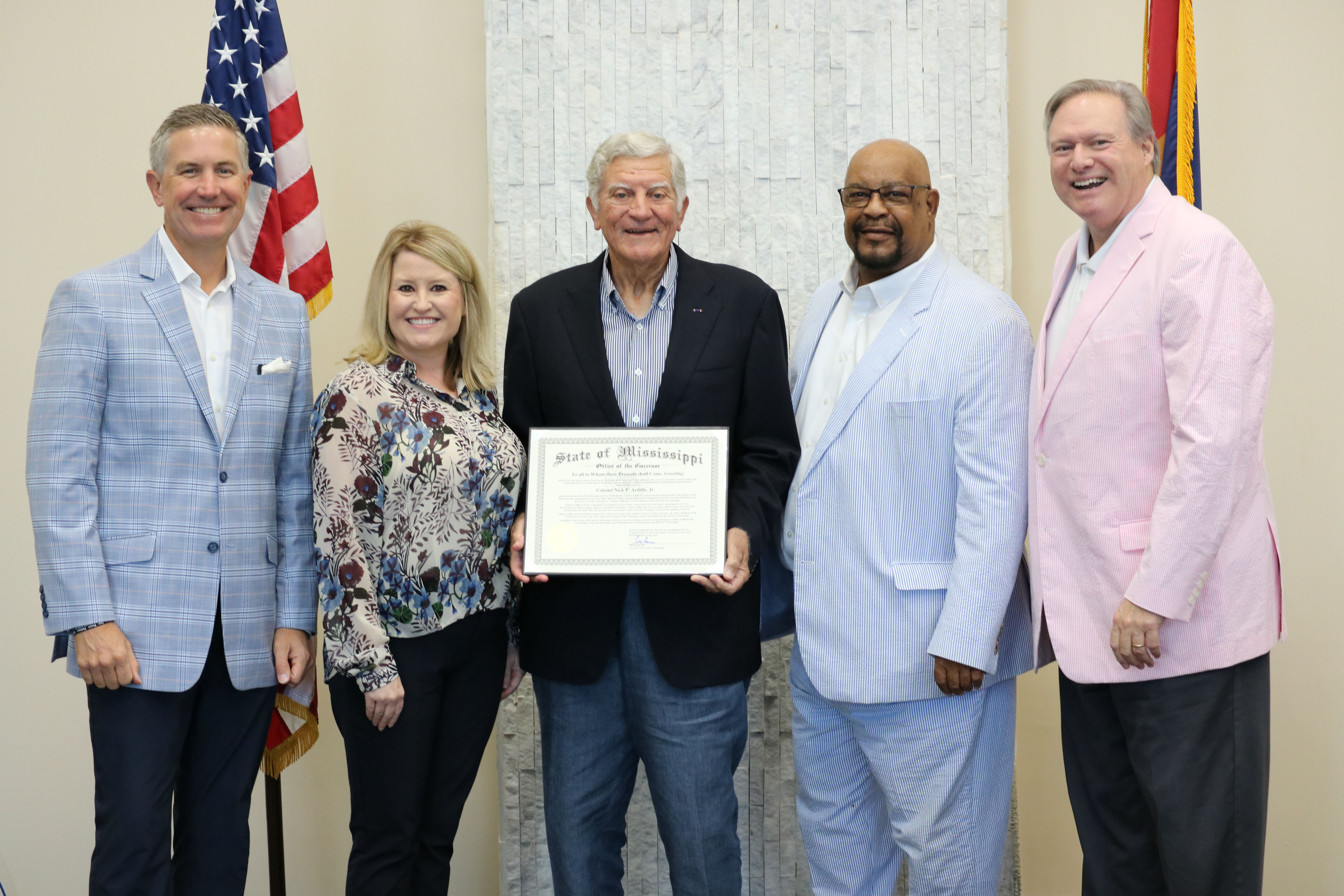 group photo of board with Ardillo holding certificate